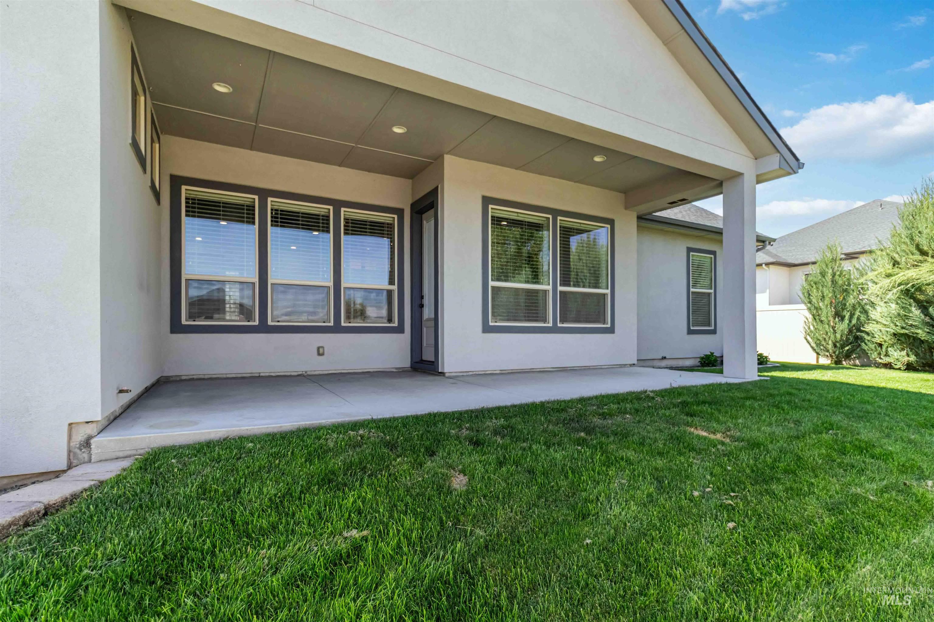3218 North Cherry Laurel Way Star, ID 83669 - Photo 46 of 50 Expansive rear yard featuring green lawn, a covered patio, and privacy fencing