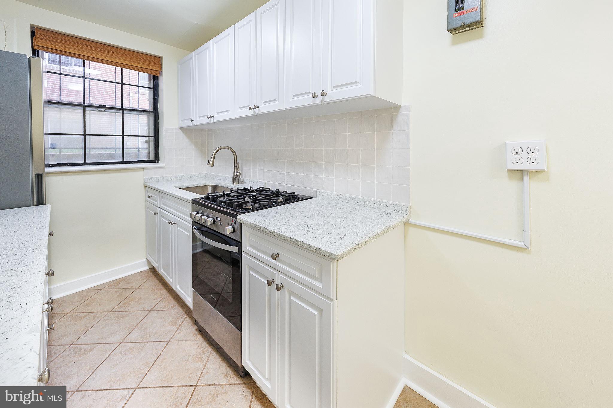 1446 Tuckerman Street Northwest, Unit A6 Washington, DC 20011 - Photo 11 of 25 a kitchen with stainless steel appliances granite countertop a stove and a refrigerator