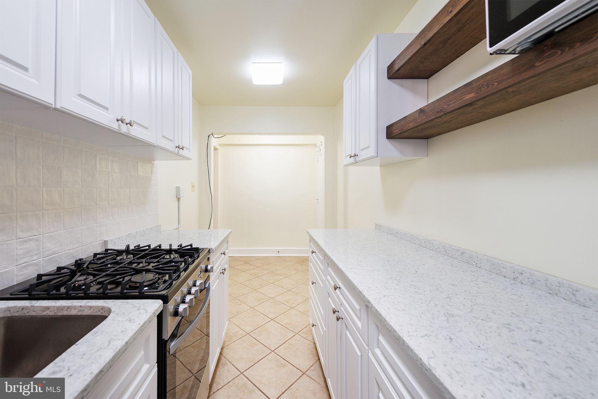 1446 Tuckerman Street Northwest, Unit A6 Washington, DC 20011 - Photo 17 of 25 a kitchen with a stove and a white cabinets