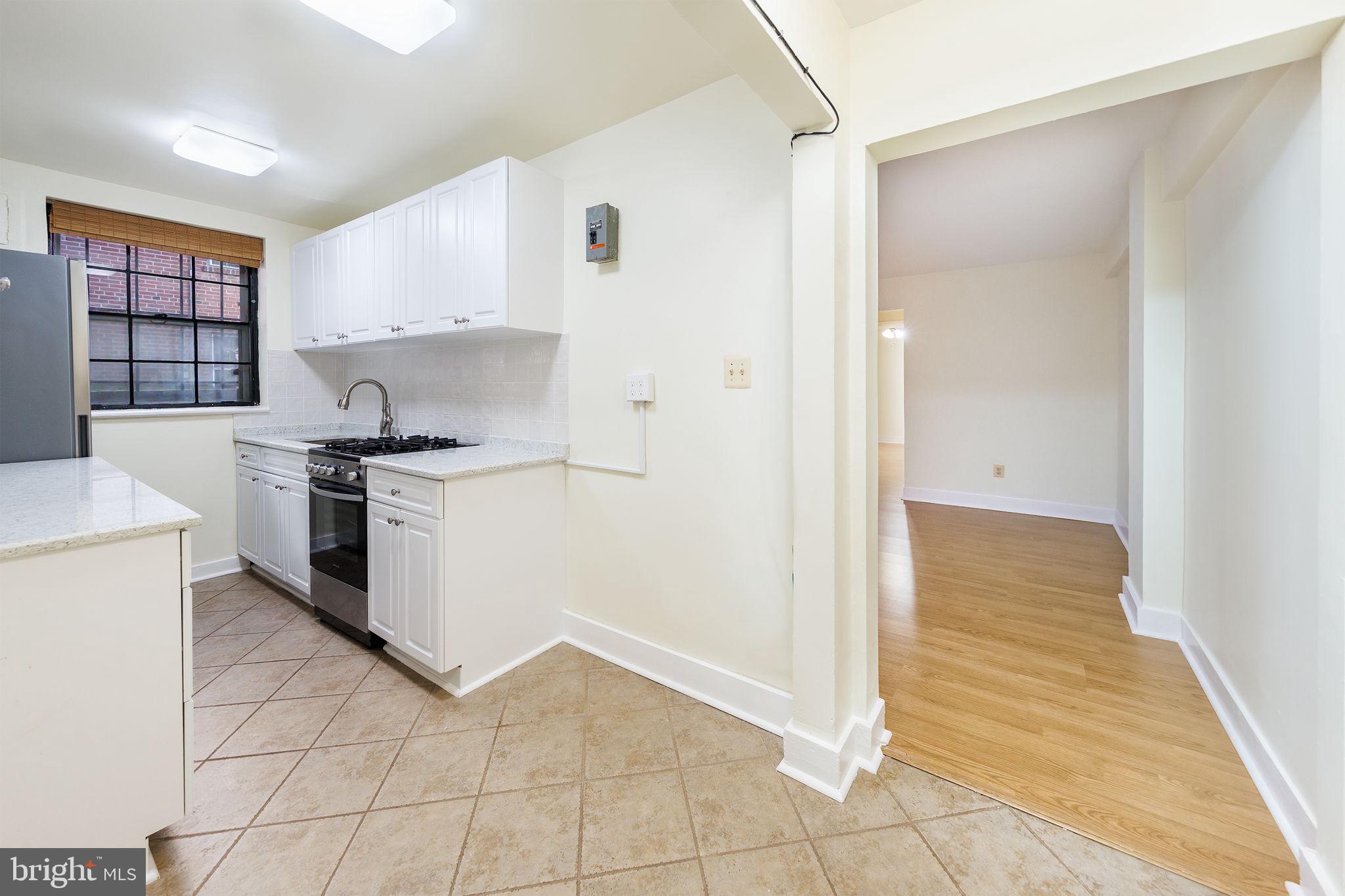 1446 Tuckerman Street Northwest, Unit A6 Washington, DC 20011 - Photo 7 of 25 a kitchen with stainless steel appliances granite countertop a stove a sink and a refrigerator
