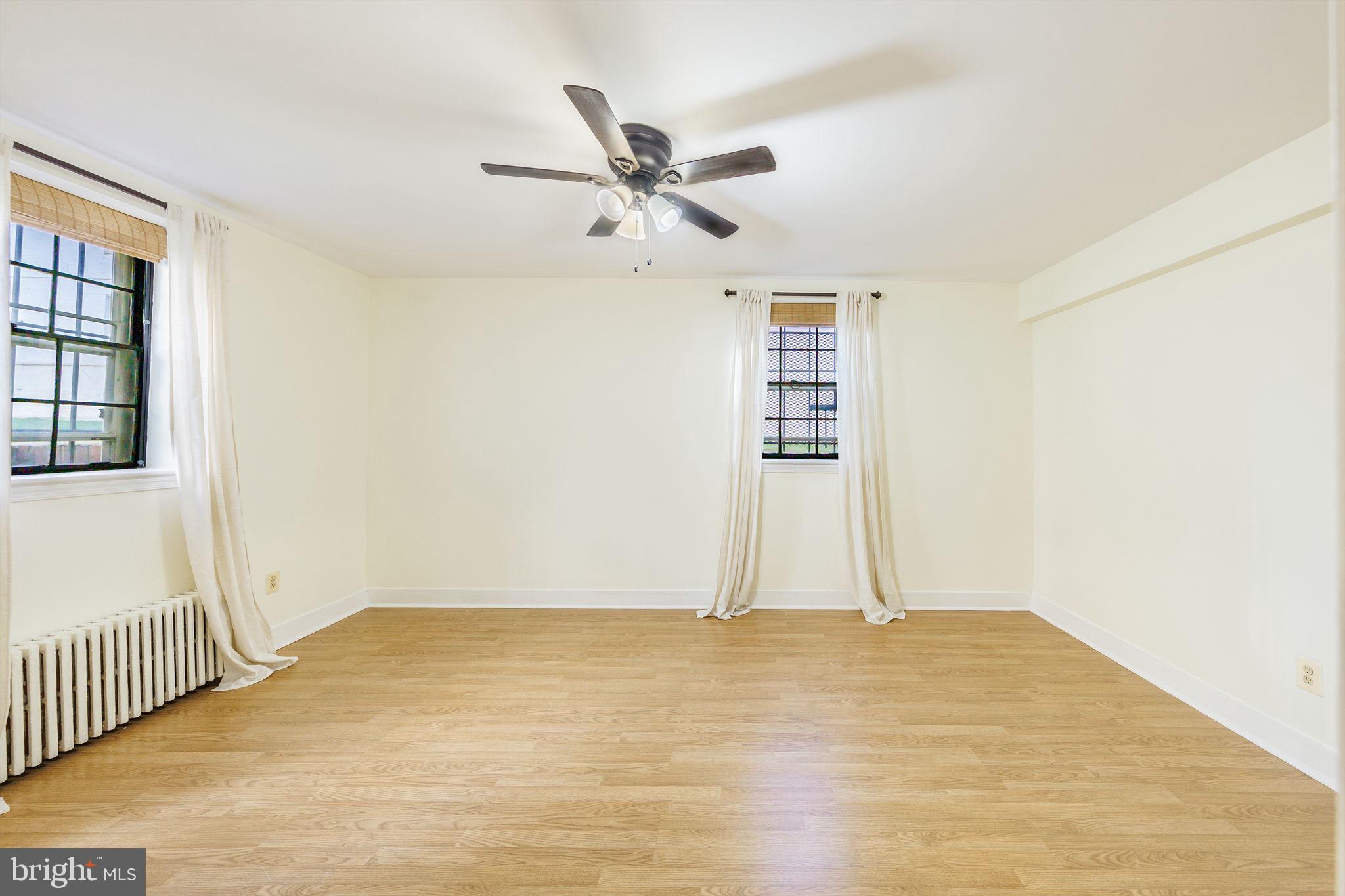 1446 Tuckerman Street Northwest, Unit A6 Washington, DC 20011 - Photo 8 of 25 a view of empty room with wooden floor and ceiling fan