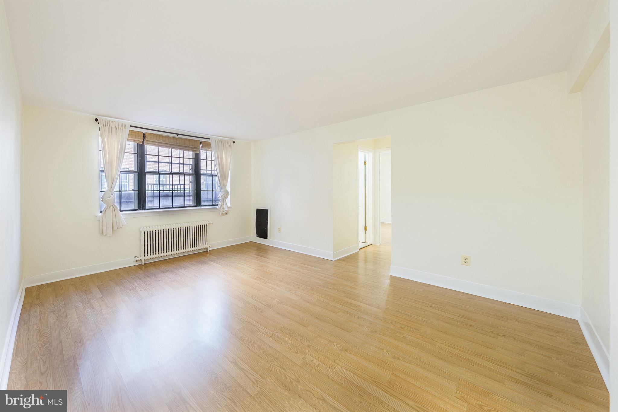 1446 Tuckerman Street Northwest, Unit A6 Washington, DC 20011 - Photo 10 of 25 an empty room with wooden floor and windows