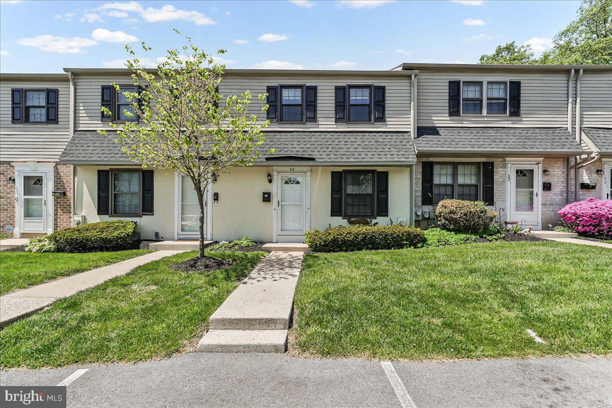 54 Norwood House Road, Unit 34 Downingtown, PA 19335 - Photo 1 of 21 a front view of a house with a yard and potted plants