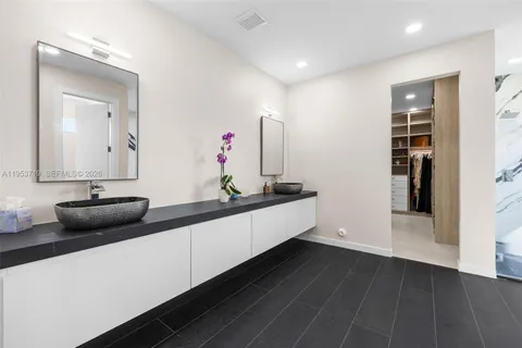 a spacious bedroom with a bed and a flat screen tv