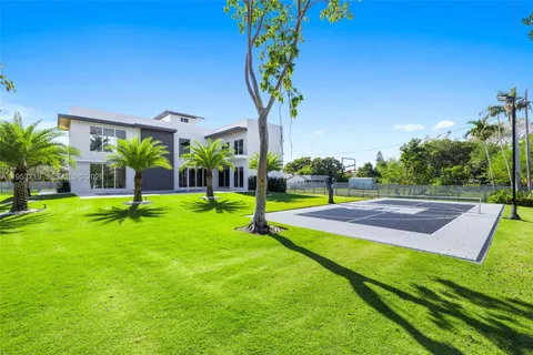 an aerial view of residential houses with outdoor space and trees