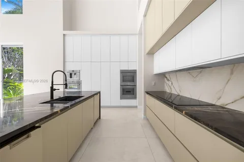 a large kitchen with a sink and cabinets