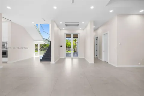 an empty room with windows and chandelier