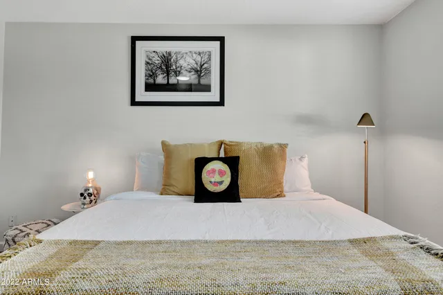 a bedroom with a bed and a painting on the wall