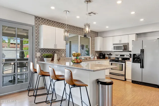 a kitchen with white cabinets and stainless steel appliances