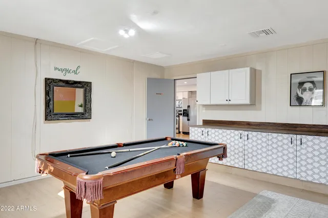a room with wooden floor and pool table