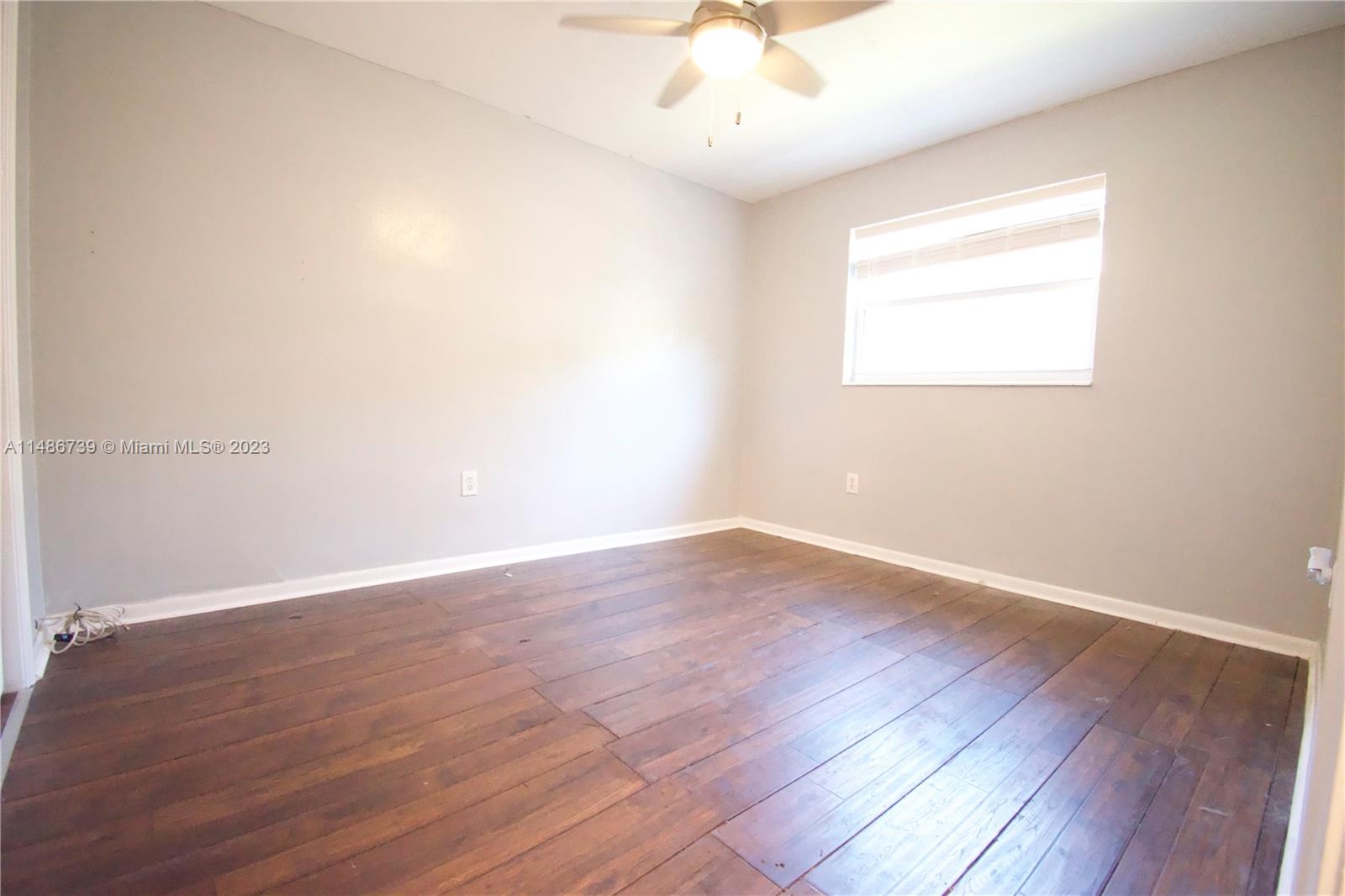 6560 Northwest 30th Street Sunrise, FL 33313 - Photo 41 of 46 an empty room with wooden floor and windows