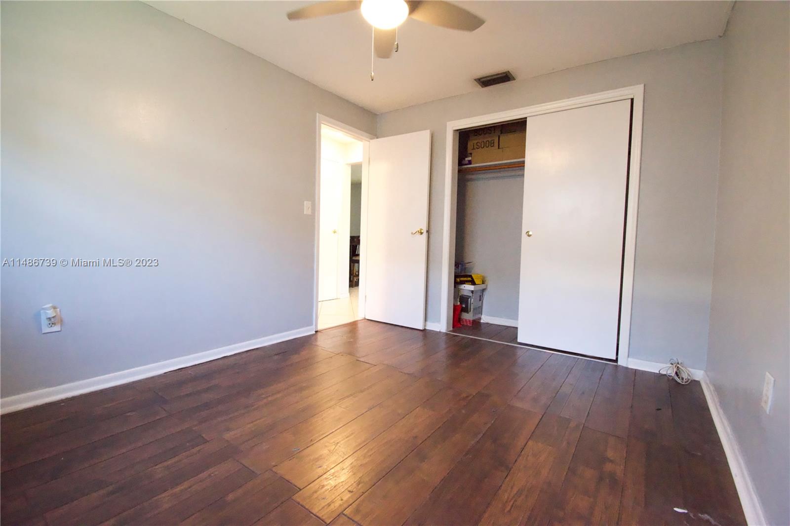 6560 Northwest 30th Street Sunrise, FL 33313 - Photo 42 of 46 a view of an empty room with wooden floor closet and a chandelier fan