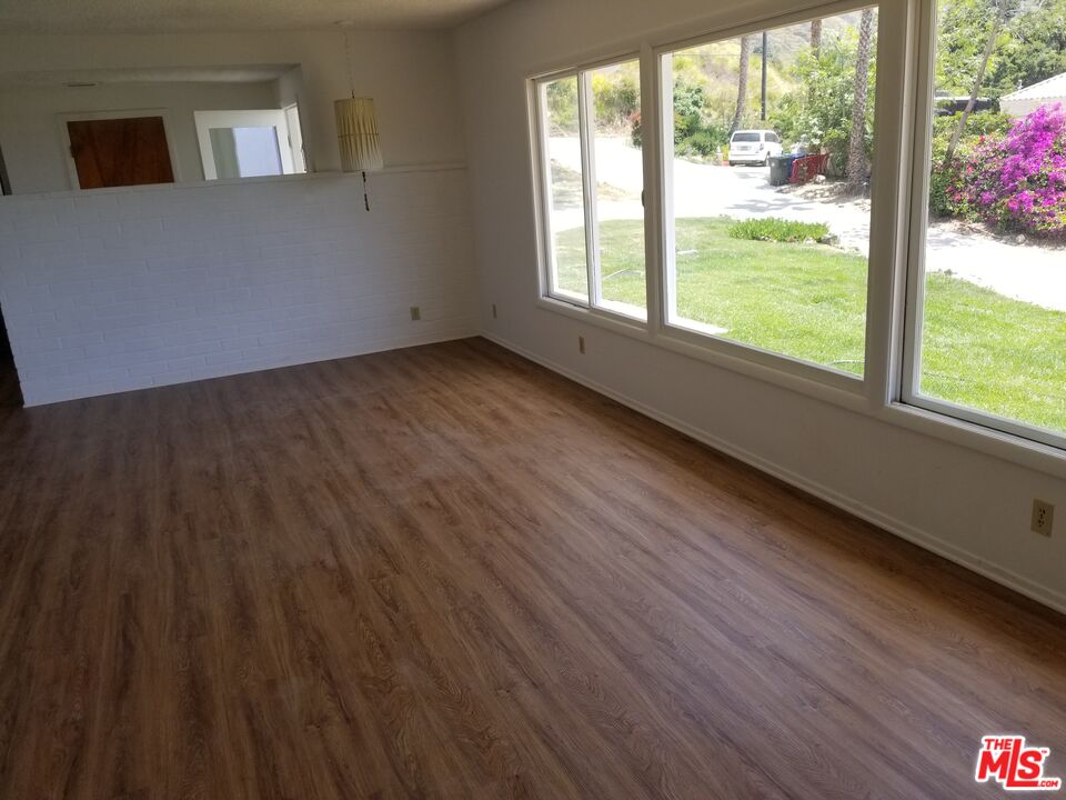 20490 Seaboard Road Malibu, CA 90265 - Photo 30 of 50 a view of an empty room with wooden floor and a window