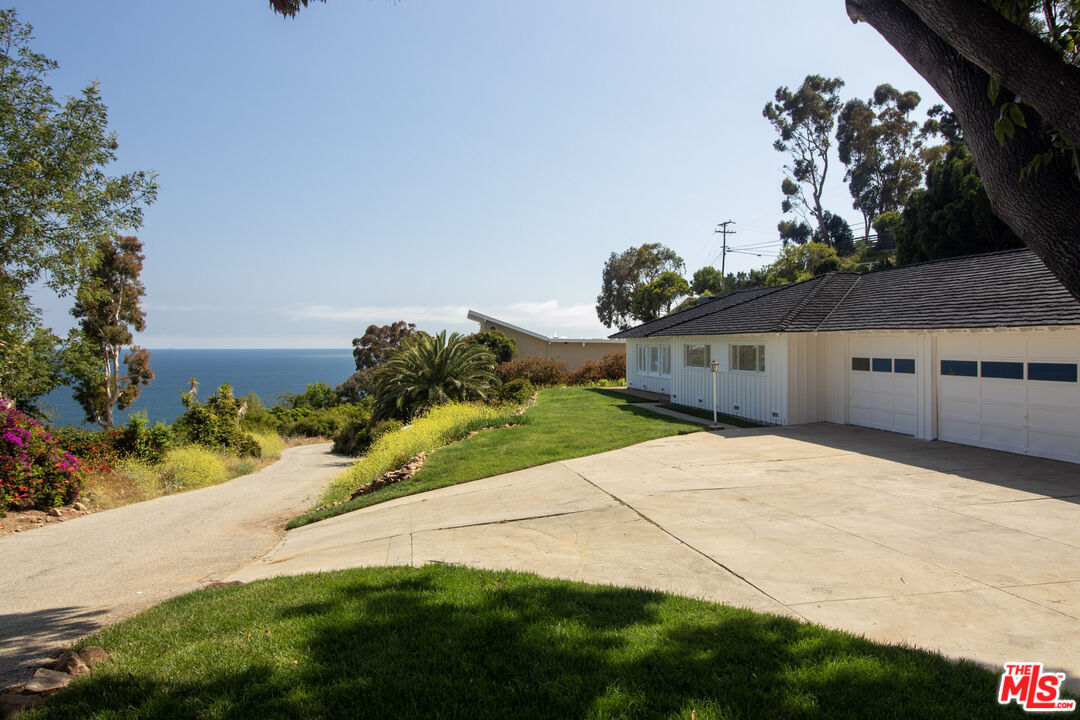 20490 Seaboard Road Malibu, CA 90265 - Photo 39 of 50 a front view of a house with a yard and garage