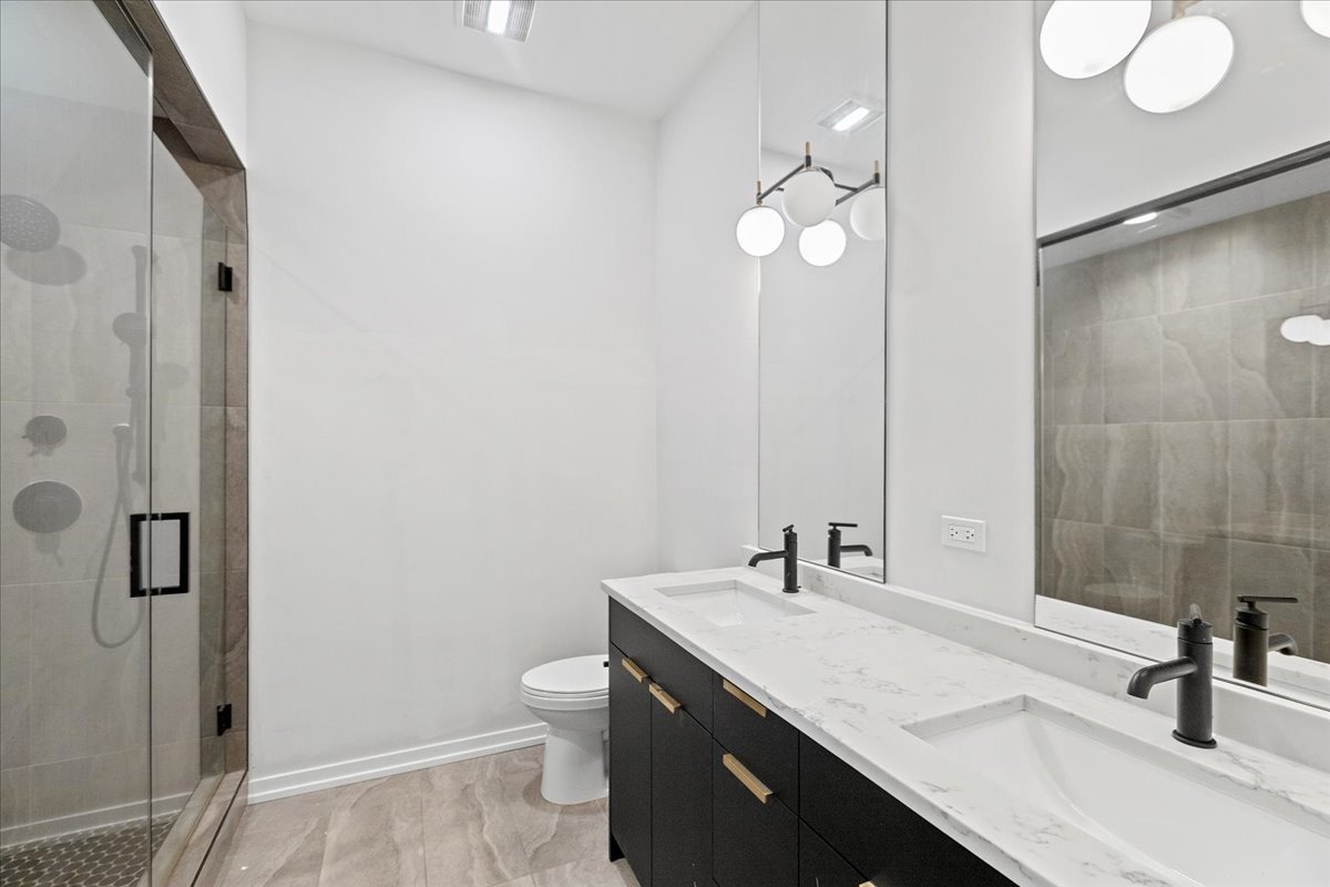 5201 South Wabash Avenue, Unit 3 Chicago, IL 60615 - Photo 9 of 11 a bathroom with a sink a toilet and a mirror
