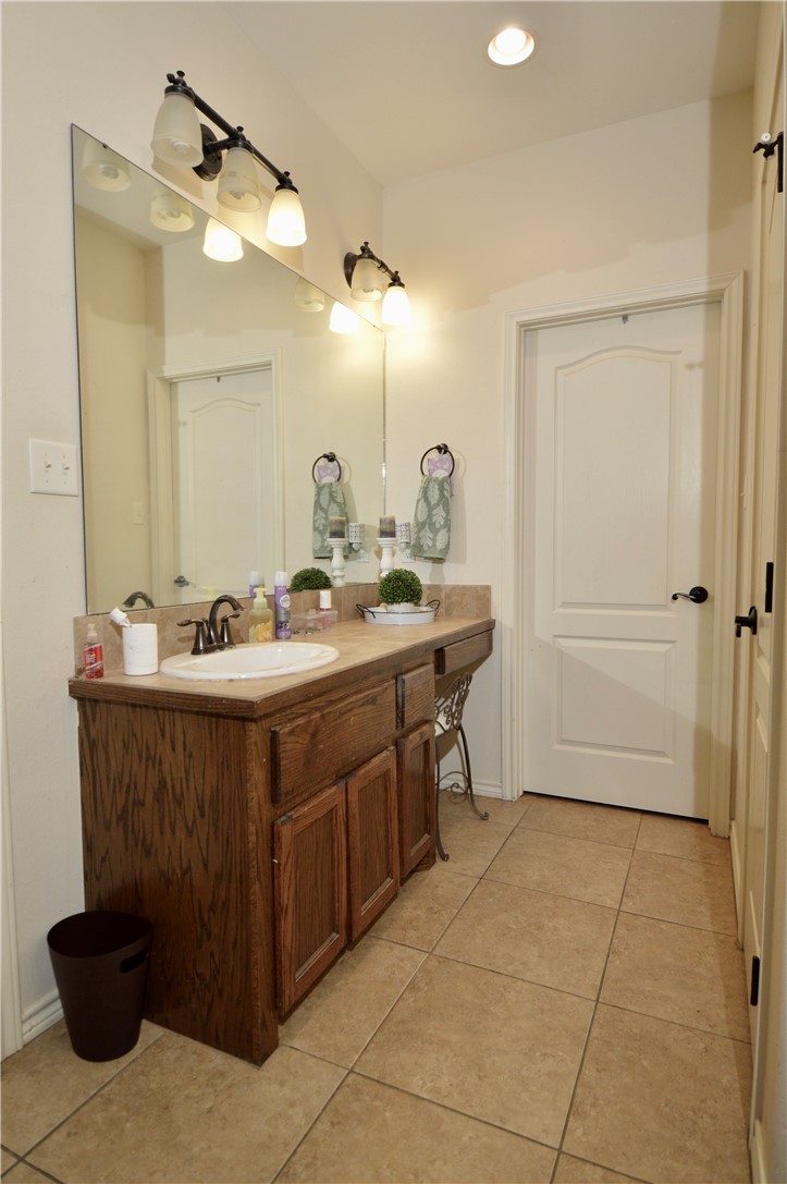 1717 Agarito Avenue Alice, TX 78332 - Photo 11 of 25 a bathroom with a sink vanity and a mirror