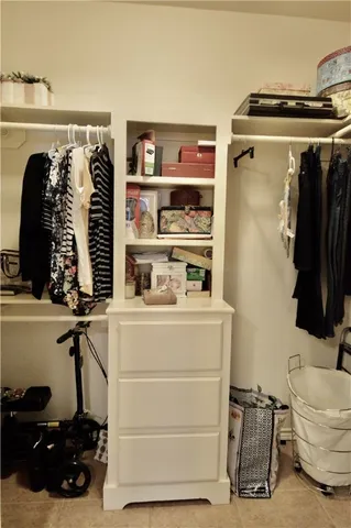 a view of walk in closet with clothes and shoes