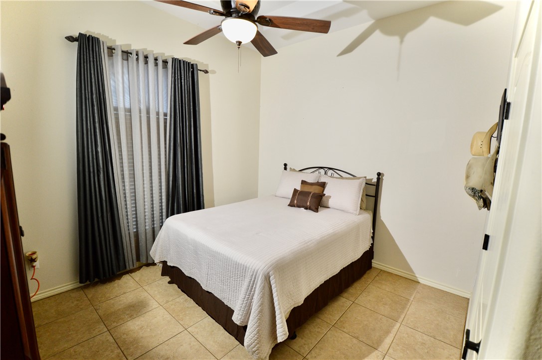 1717 Agarito Avenue Alice, TX 78332 - Photo 16 of 25 a bedroom with a bed and a chandelier