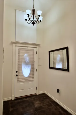 a view of a hallway with wooden floor and chandelier