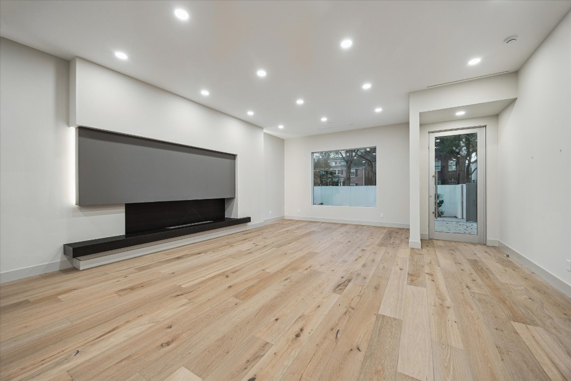2129 Quenby Street Houston, TX 77005 - Photo 5 of 39 a view of empty room with wooden floor and fireplace