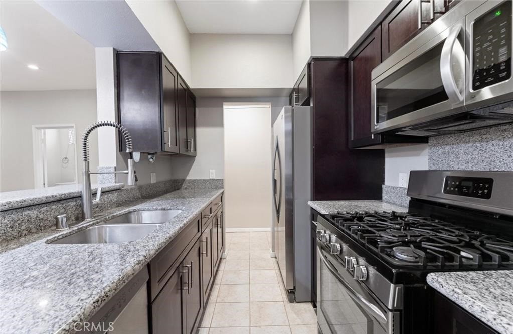 4705 Kester Avenue, Unit 209 Sherman Oaks, CA 91403 - Photo 12 of 18 a kitchen with stainless steel appliances granite countertop a sink stove a refrigerator and microwave