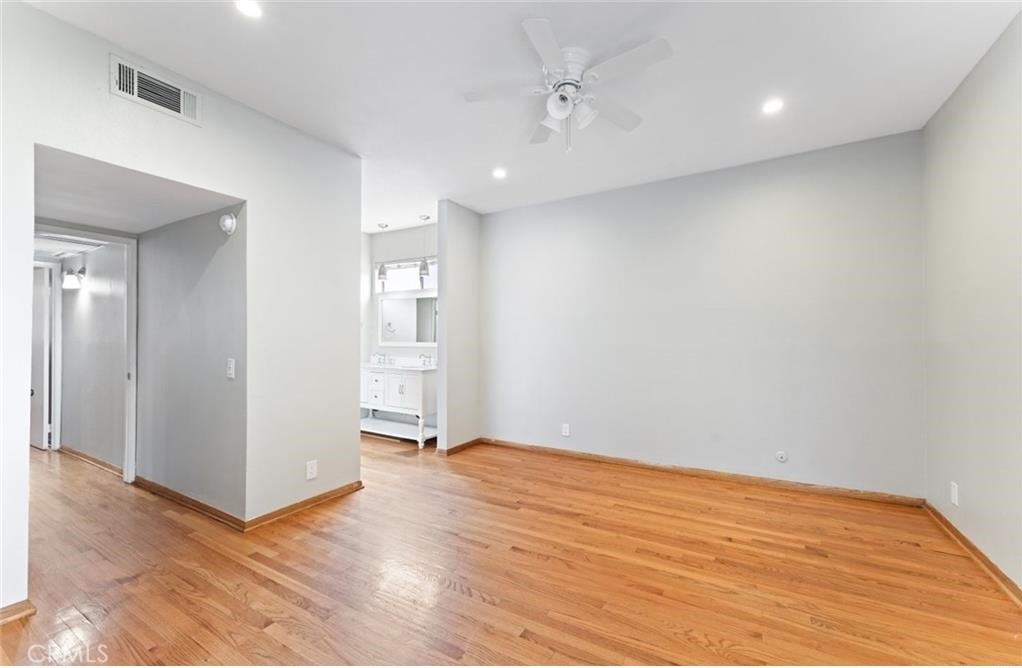 4705 Kester Avenue, Unit 209 Sherman Oaks, CA 91403 - Photo 13 of 18 a view of an empty room with wooden floor and a kitchen