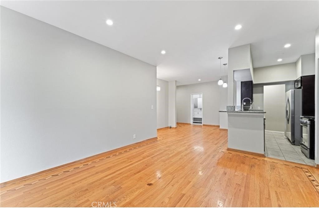 4705 Kester Avenue, Unit 209 Sherman Oaks, CA 91403 - Photo 10 of 18 a large space with large kitchen island a sink wooden floor and stainless steel appliances
