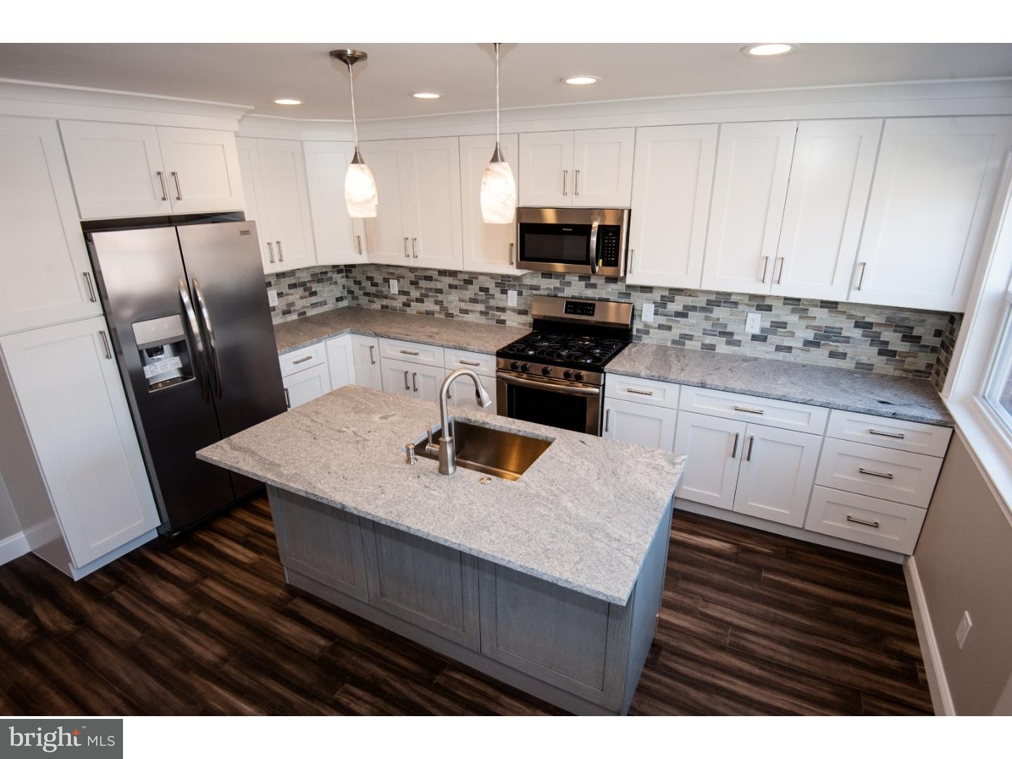 a kitchen with white cabinets sink and stainless steel appliances