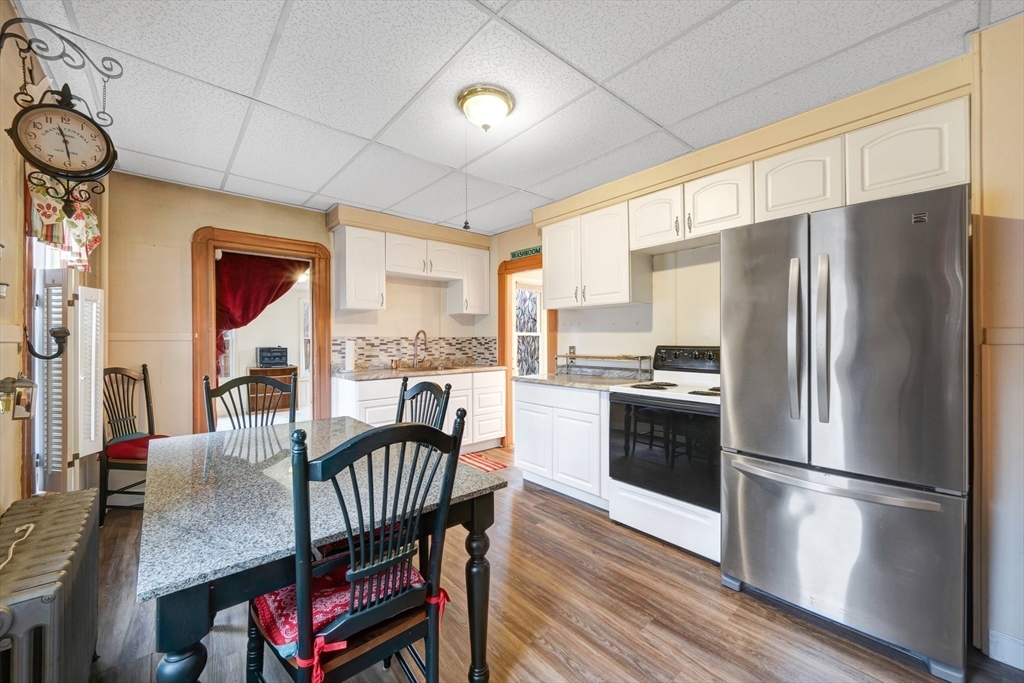 62 Fargo Street Springfield, MA 01119 - Photo 8 of 38 a kitchen with stainless steel appliances granite countertop a refrigerator a stove and a dining table with wooden floor