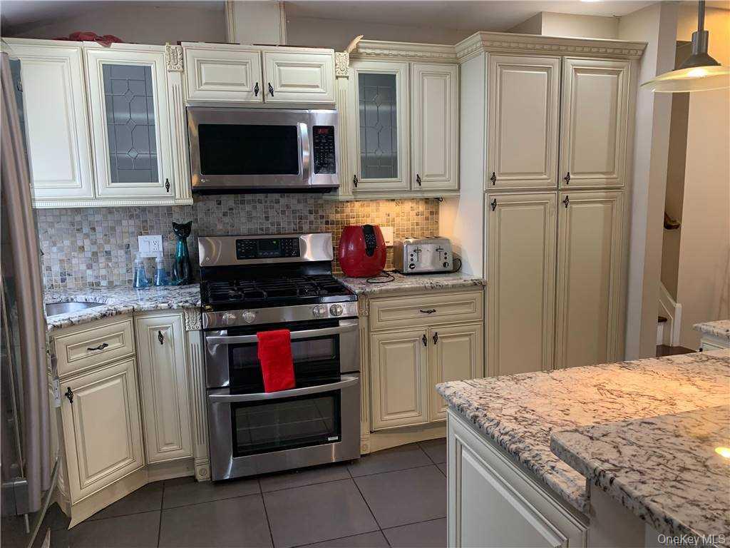 137-33 158th Street Queens, NY 11434 - Photo 2 of 21 a kitchen with stainless steel appliances granite countertop a stove and a microwave
