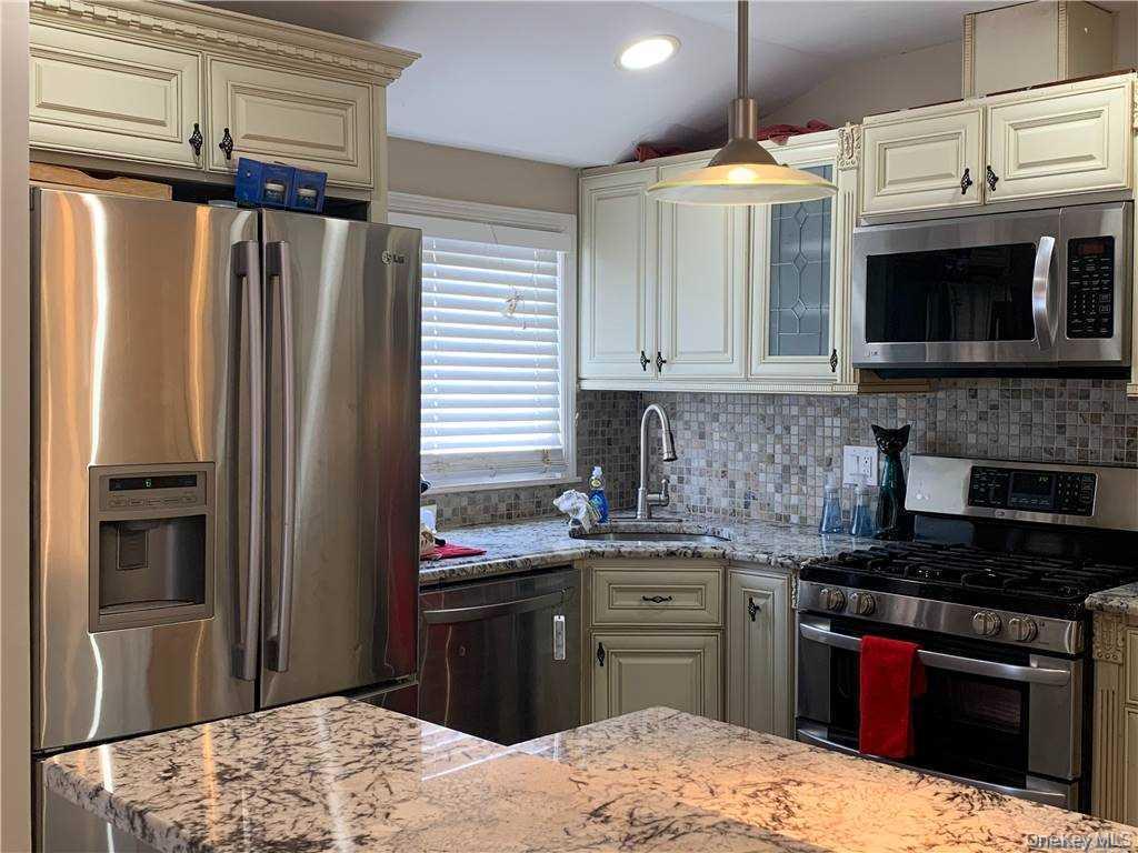 137-33 158th Street Queens, NY 11434 - Photo 3 of 21 a kitchen with granite countertop a refrigerator stove and microwave