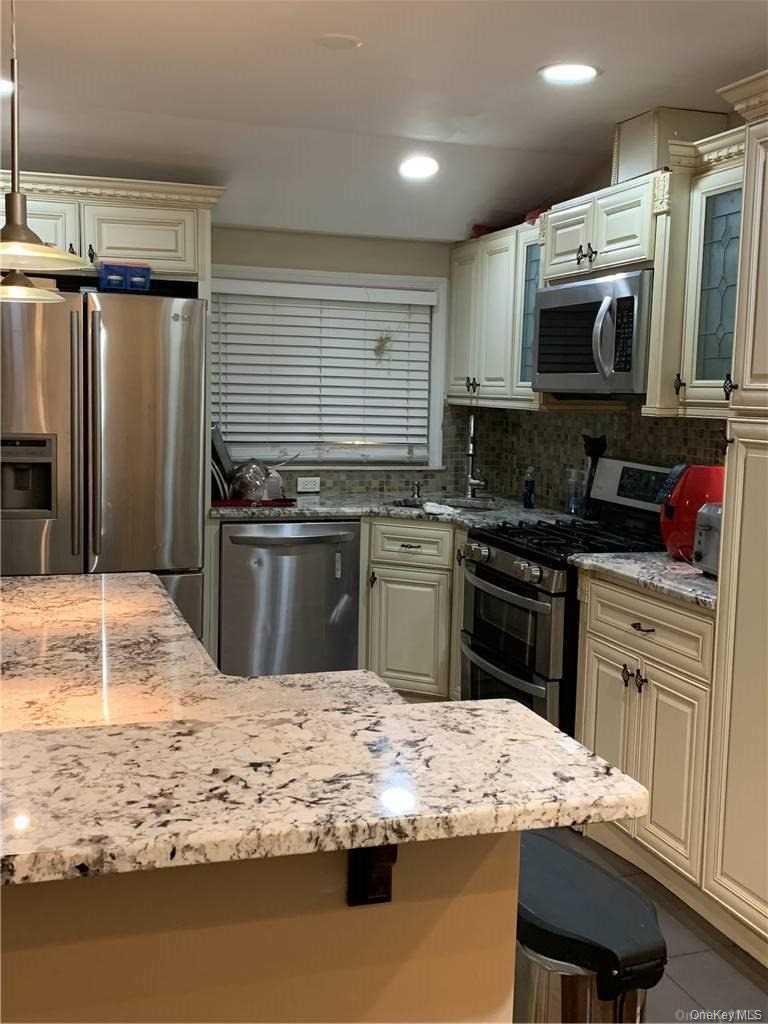 137-33 158th Street Queens, NY 11434 - Photo 4 of 21 a kitchen with kitchen island granite countertop a stove sink and microwave
