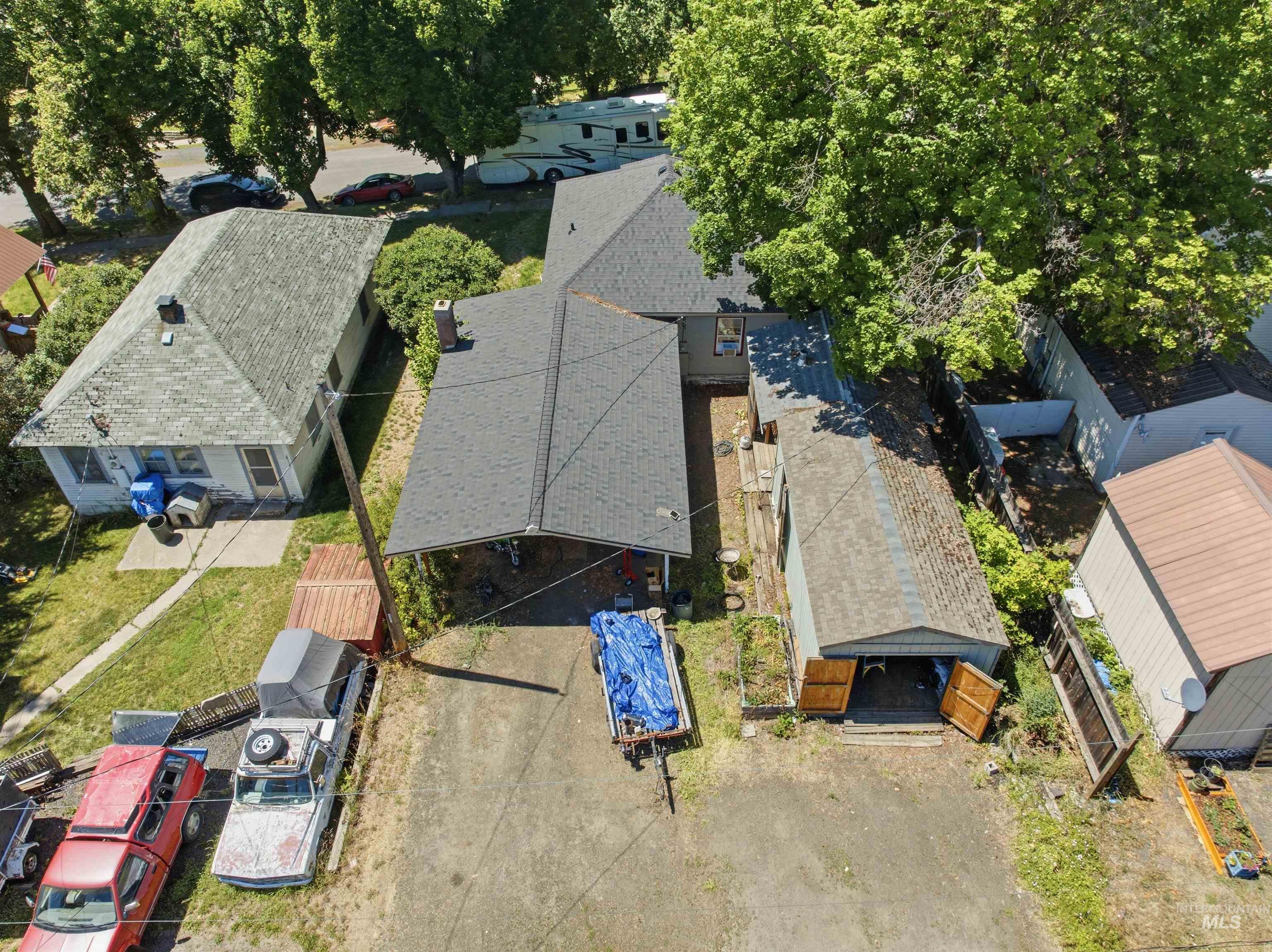 735 Oak Street Potlatch, ID 83855 - Photo 24 of 30 Property featuring a main residence with a dark gray shingle roof, an attached covered carport, and a detached outbuilding with double wood doors