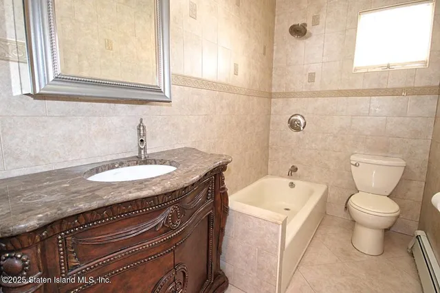 a bathroom with a granite countertop sink and a toilet