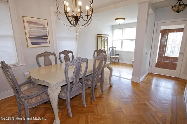 a dining room with furniture a chandelier and wooden floor