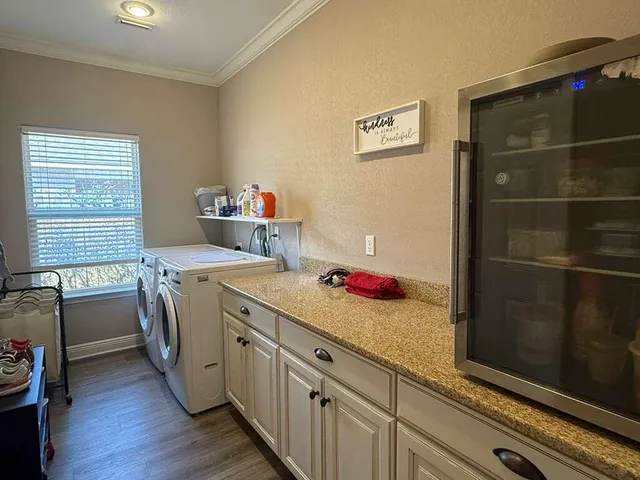 a front view of a house with yard and trees in the background