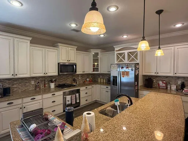 a kitchen with a granite countertop sink a counter and chairs