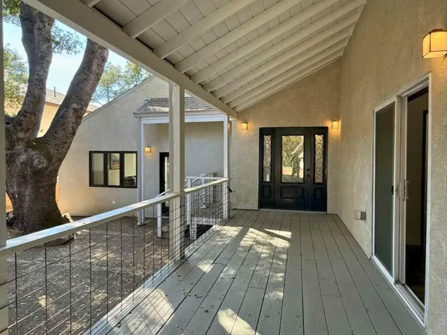 a view of balcony with wooden floor and fence