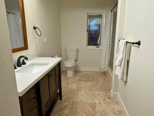 a bathroom with a sink and mirror with toilet