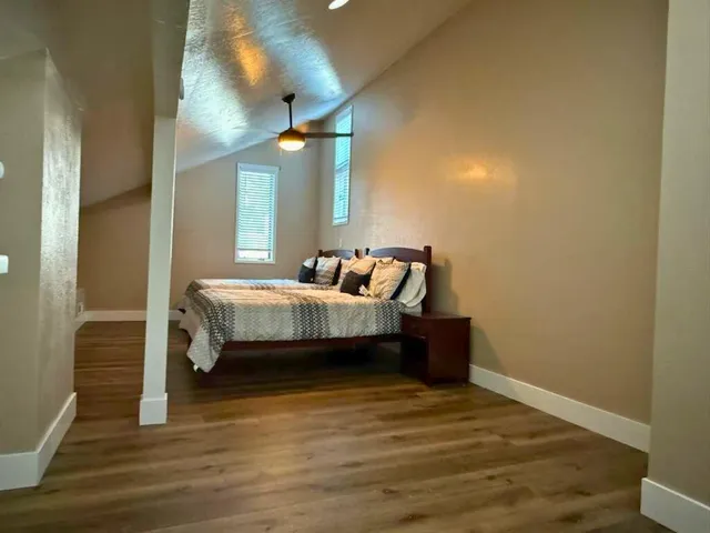 a bedroom with a bed and wooden floor