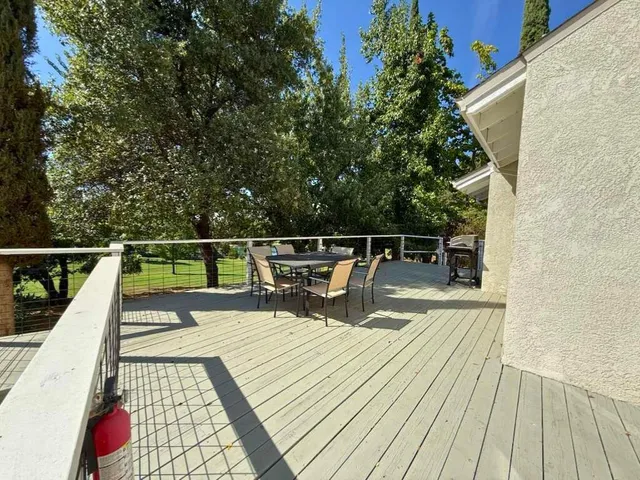 a view of a balcony with wooden floor and fence