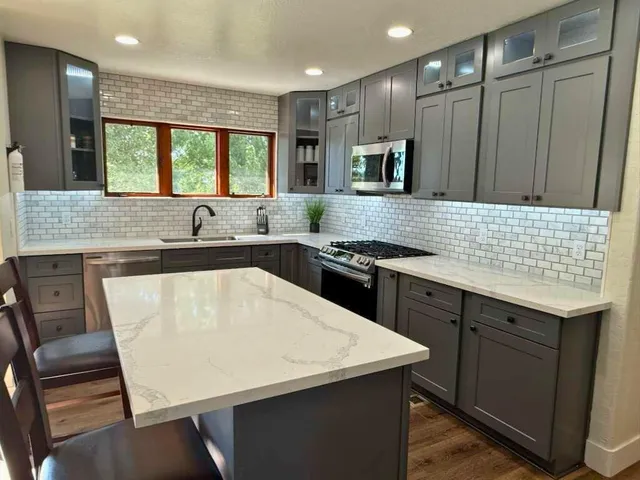 a kitchen with kitchen island a sink table and chairs