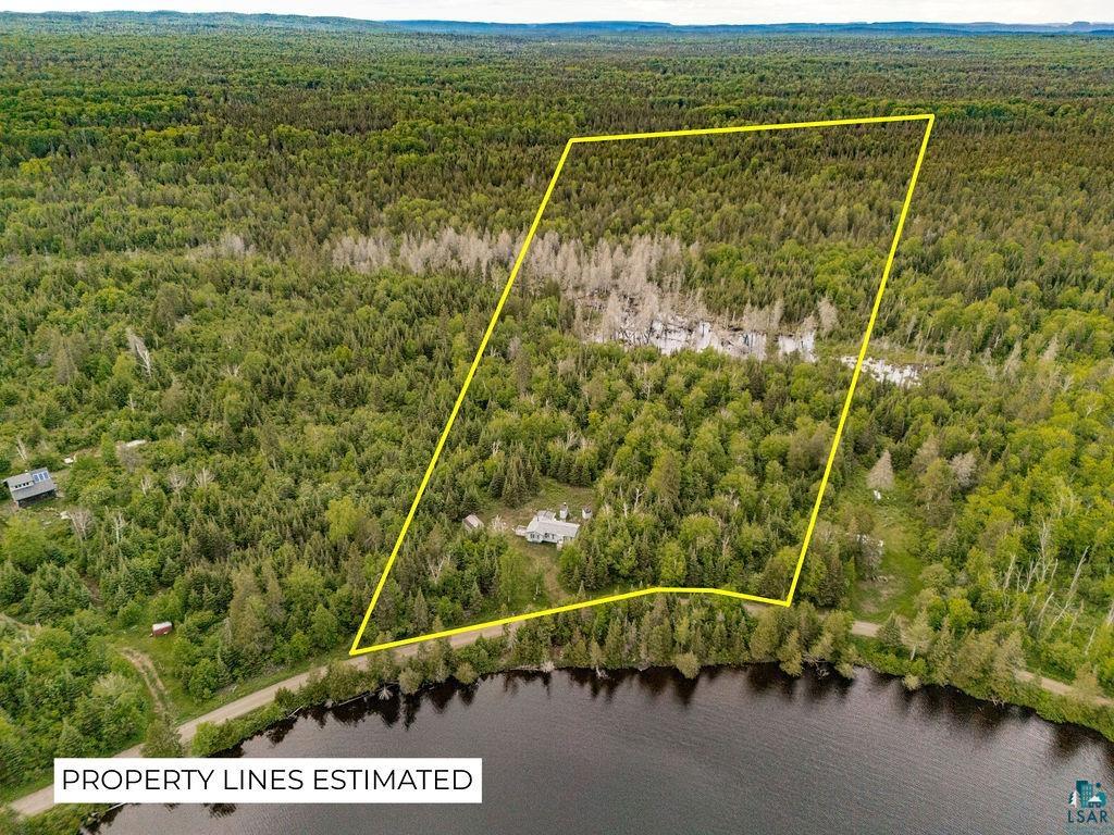 1268 Tom Lake Road Hovland, MN 55606 - Photo 28 of 56 Expansive wooded property with a shoreline along a body of water, featuring a visible dwelling