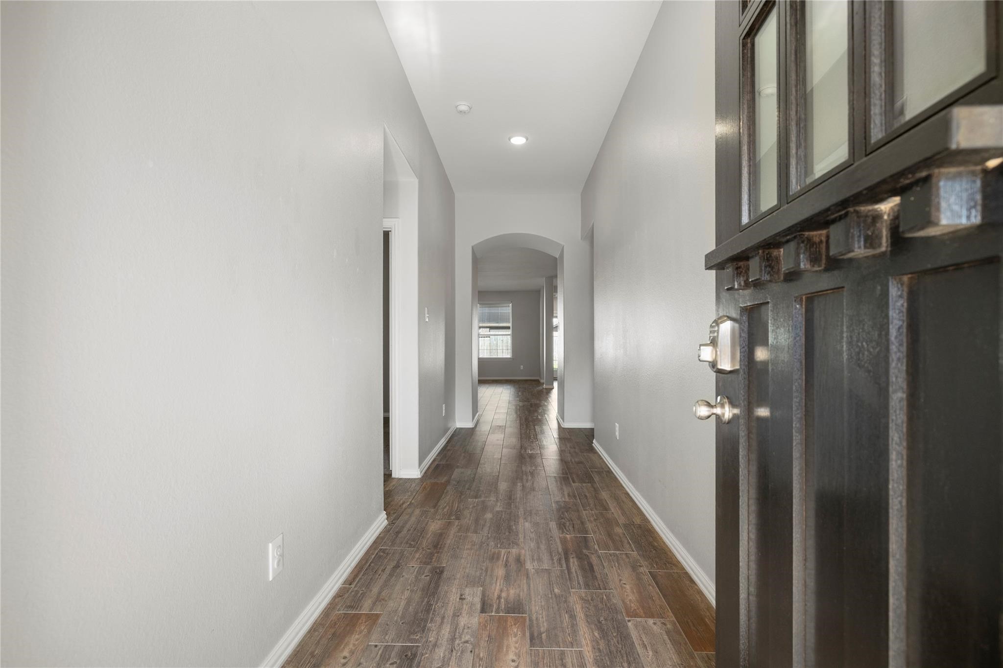 29507 Whitebrush Trace Drive Spring, TX 77386 - Photo 28 of 32 Interior hallway with wood-look flooring and arched entry detail.