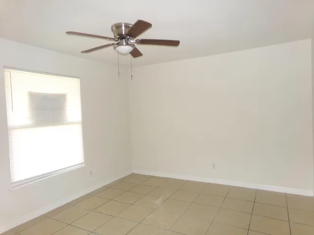 an empty room with a window and a fan