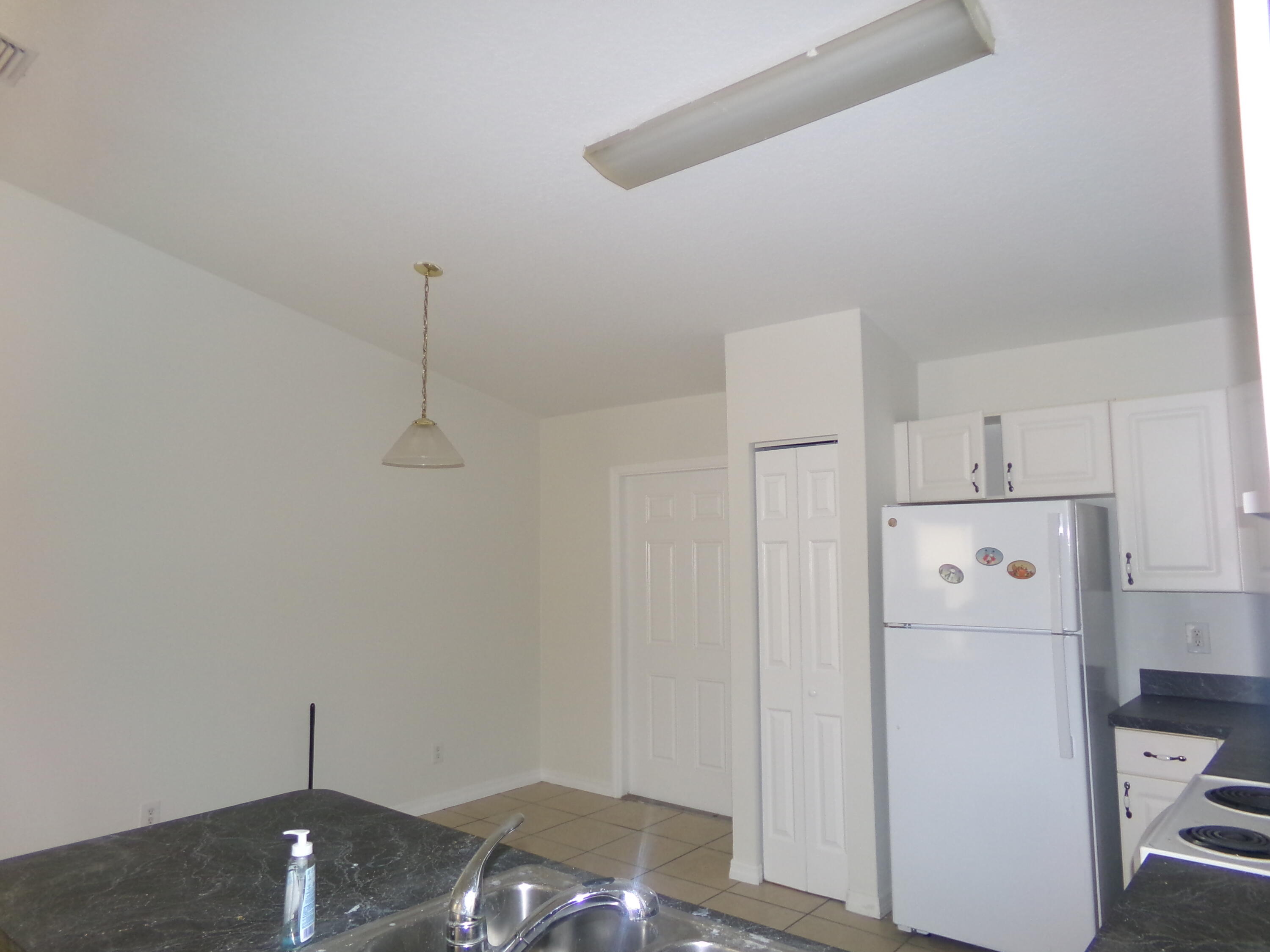 319 15th Street Southwest Vero Beach, FL 32962 - Photo 3 of 9 a view of a kitchen with refrigerator and white cabinets