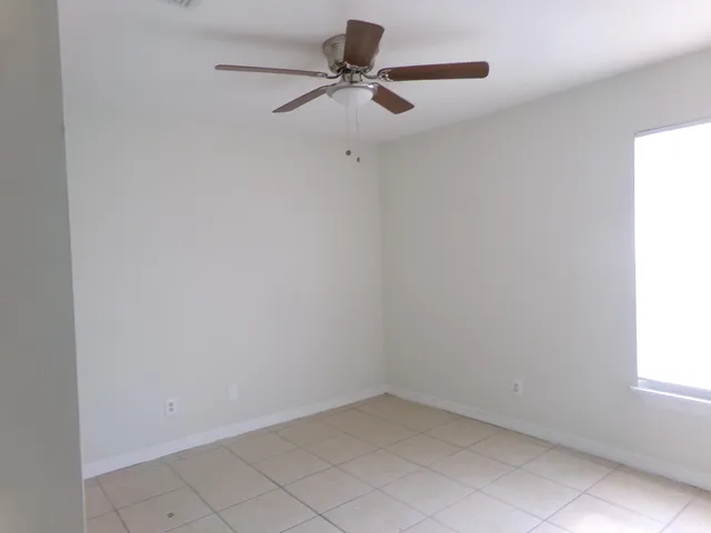 a room with a window and a ceiling fan