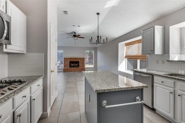 a kitchen with granite countertop a sink stove and cabinets