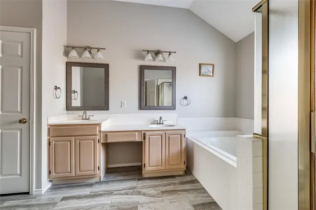 a bathroom with a tub sink and mirror