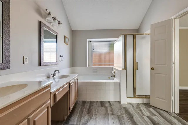 a spacious bathroom with a tub sink and mirror